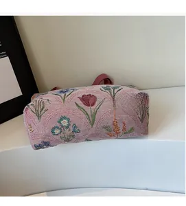 Detail of floral woven tote bag showing pink fabric texture and tulip embroidery