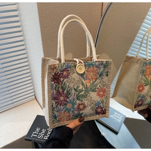 Detailed close-up of floral jacquard lunch bag with a large wood button and rope handles