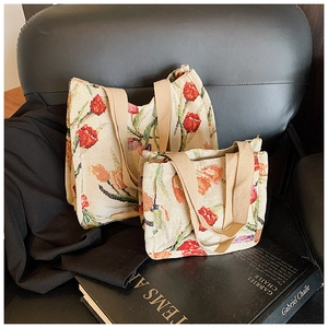 Dettaglio di borse tote in maglia grandi e piccole con motivi di tulipani rossi