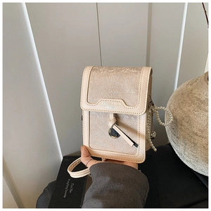 Detail of beige jacquard phone bag with pearl chain and leather patchwork texture