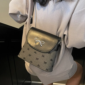 Fashionable black and grey crossbody bucket bag featuring metal bow and bow-knot print