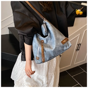 Detail of light blue hobo tote bag with brown straps and detachable round coin purse