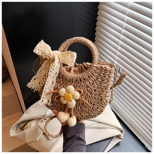 Détail du sac seau en paille fait main avec nœud en dentelle et doublure marron