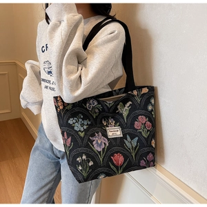 Detail of floral canvas tote bag showing woven texture and sturdy black ribbon handles