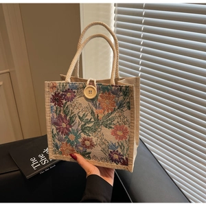 Detail of floral tapestry tote with cotton rope handles and a wooden button closure