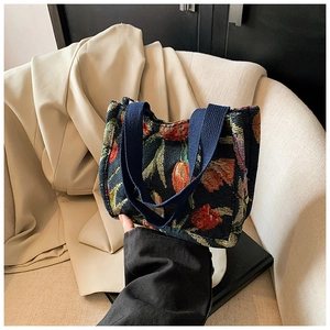 Dettaglio della borsa tote blu navy con motivo jacquard a tulipani rossi e manici