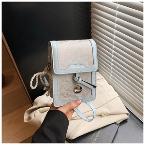 Detail of light blue textured leather phone bag with woven fabric and pearl charm