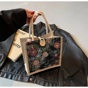 Detail of floral tapestry linen handbag with rope handle and large wooden button closure