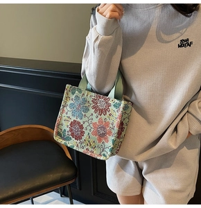 Detail of retro floral jacquard tote bag with textured flower pattern and woven handle