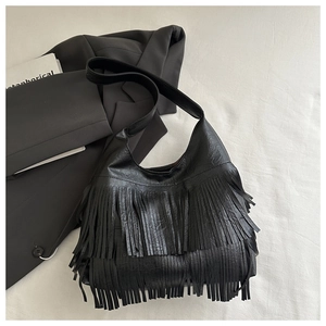 Close-up of black PU leather crossbody bag featuring tiered fringe and wide shoulder strap
