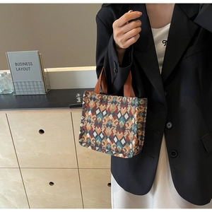Detail of bohemian tote bag with colorful geometric diamond patterns and woven texture