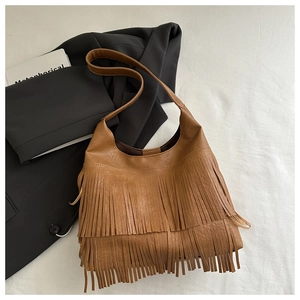 Detail of vintage brown hobo bag featuring double-layered tassels and fine PU leather texture