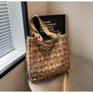 Close-up of geometric jacquard tote bag with colorful woven patterns on a metal table