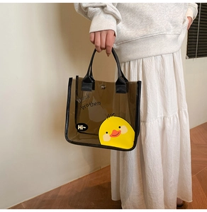 Détail d'un sac cabas transparent en PVC marron avec un motif de canard mignon