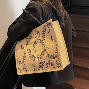 Detail of large jute tote bag with black vine patterns and thick rounded handles