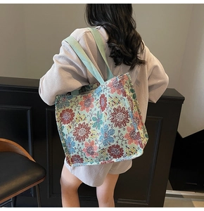 Detailed view of the colorful floral jacquard pattern and sturdy handles of this tote bag