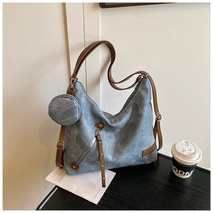 Close-up of vintage blue tote bag featuring side coin purse and distressed texture