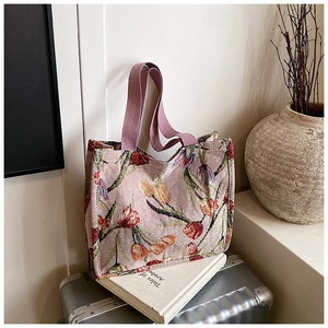 Dettaglio della borsa tote jacquard con motivi di tulipani su valigia d'argento