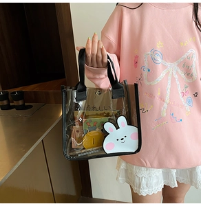 Détail d'un sac transparent en PVC avec un motif de lapin mignon et un bouton-pression chic