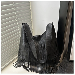 Detail of black hobo bag with long fringes and pebbled faux leather texture