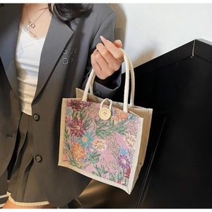 Close-up of floral jacquard tote bag with rustic cotton rope handles and wood button detail