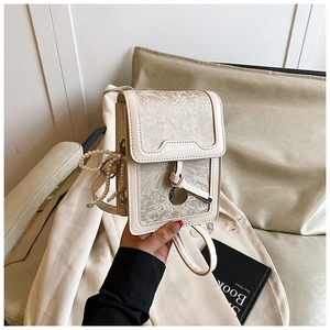 Detailed shot of jacquard cream crossbody bag with floral pattern and pearl chain