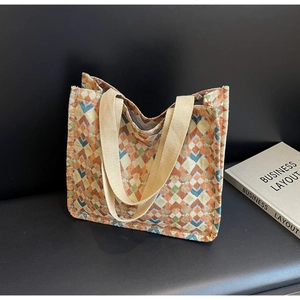 Close-up of geometric woven tote bag featuring colorful canvas diamond patterns and sturdy straps