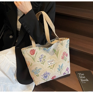 Close-up of floral canvas tote bag with colorful tulips and embroidered brand label