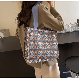 Detailed macro view of bohemian jacquard tote bag with geometric diamond patterns and wide strap