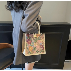 Detailed view of floral jacquard linen tote bag with woven rope handles and wood button