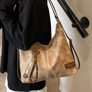 Vintage brown leather tote bag with rivet details and shoulder strap for women