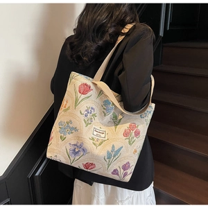 Floral canvas tote bag featured in a lifestyle setting with a detailed woven texture