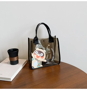 Détail d'un sac cabas transparent gris avec un motif de dessin animé et des anses noires