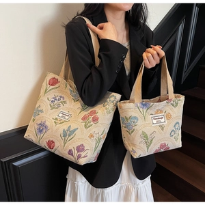 Detail of floral tapestry tote bags in two sizes featuring intricate colorful embroidery