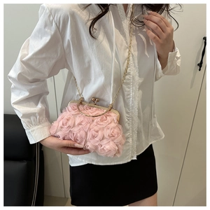 Detailed close-up of pink chiffon rose petals and golden ball clasp on evening clutch bag