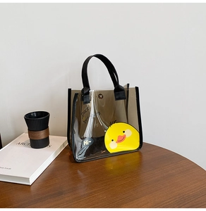 Détail du sac cabas transparent marron avec motif canard jaune et anses en nylon noir