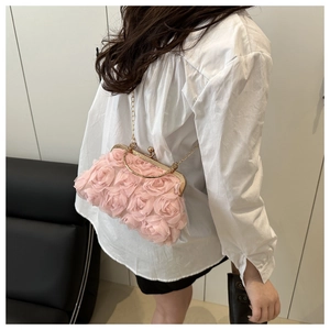 Pink chiffon rose shoulder bag with gold chain strap shown on model in social setting