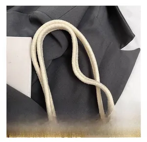 Detail of reinforced rope handles and intricate lace edges on the woven tote bag
