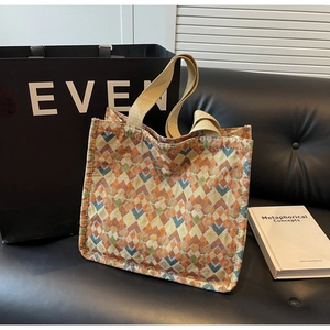 Detailed close-up of retro geometric rhombus pattern and beige canvas handle on a tote bag