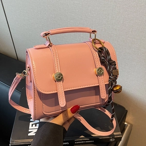 Pink vintage faux leather crossbody bag with golden hardware and braided charm