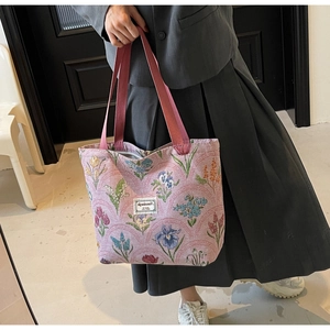 Detail of pink floral jacquard tote bag featuring tulip patterns and canvas handles