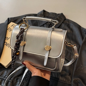 Silver metallic square crossbody bag with gold hardware and stylish braided charm