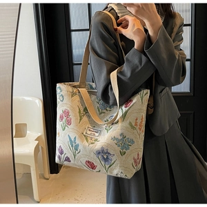 Detail of floral tapestry canvas tote bag with jacquard fabric and woven shoulder strap