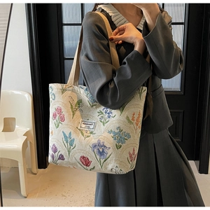 Close-up of floral canvas tote bag featuring retro tulip print and textile texture