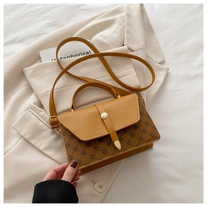 Detail of vintage square crossbody bag with brown pattern and yellow leather flap