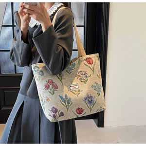 Floral jacquard tote bag with vintage patterns worn over the shoulder by a model