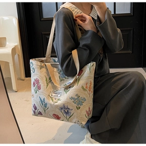 Close-up of vintage floral canvas tote bag showing the textured fabric and sturdy handles