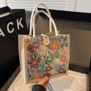 Linen lunch bag with floral print, woven handles and large wood button closure
