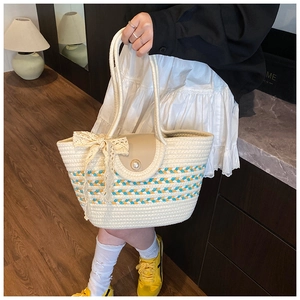 Detail of woven beach tote with lace bow, pearl buckle and blue-yellow stripes