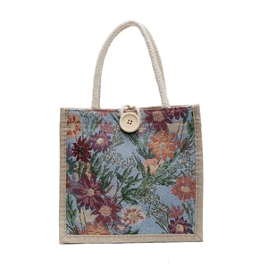 Linen bento lunch bag with vibrant floral pattern and natural woven rope handles